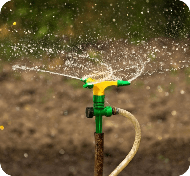 A green and yellow water hose is spraying.