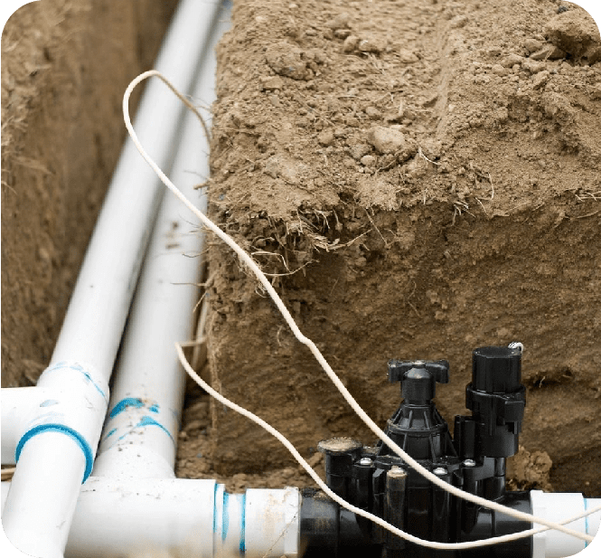 A pipe laying on top of the ground next to two pipes.