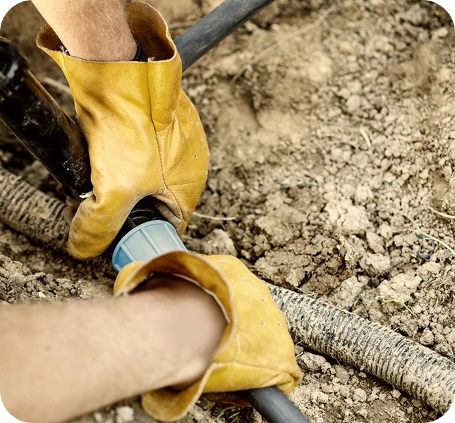 A person wearing yellow boots and holding onto a pair of blue gloves.